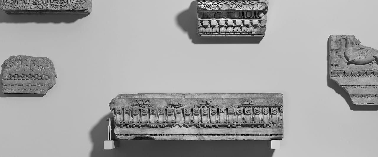 Five carved marble architectural fragments arranged in a row.